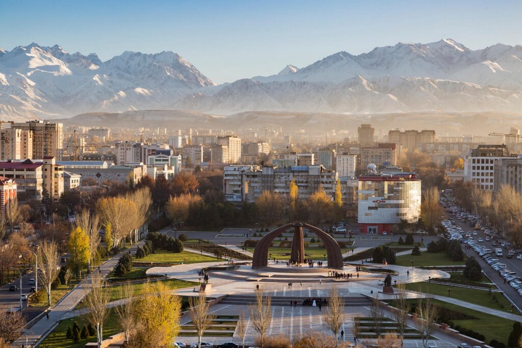 Bishkek city center featuring monuments, wide avenues, and the Tien Shan mountains in the background
